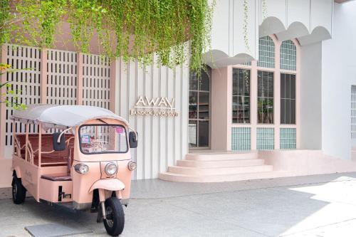 a pink scooter parked in front of a building at Away Bangkok Sukhumvit in Bangkok