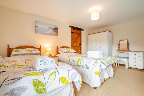 a bedroom with two twin beds and a dresser at 3 Bed in Woodford oc-w32062 in Kilkhampton