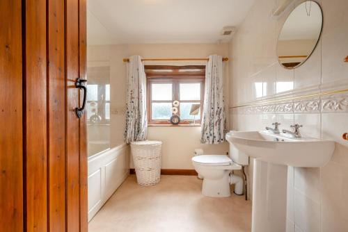 a white bathroom with a sink and a toilet at 3 Bed in Woodford oc-w32062 in Kilkhampton
