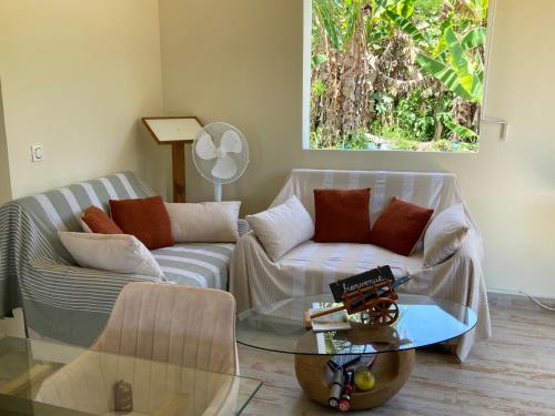 a living room with two couches and a glass table at Villa Surette in Capesterre