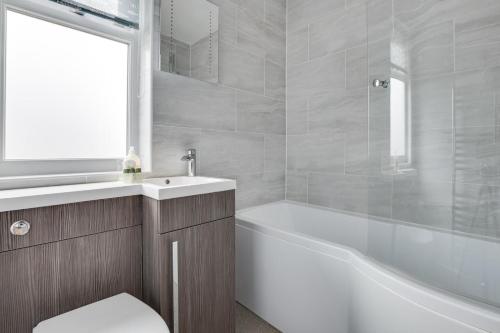 a bathroom with a tub and a toilet and a sink at 1 Bed in Seahouses oc-gd1735 in Seahouses