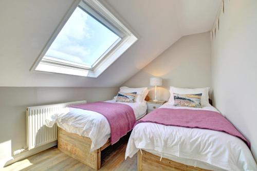 two beds in a attic bedroom with a window at 2 Bed in Crackington Haven oc-p00596 in Crackington Haven