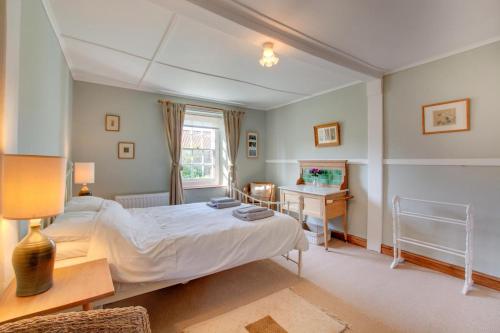 a bedroom with a bed and a desk and a window at 2 Bed in Docking oc-913 in Docking