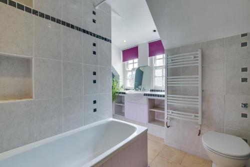 a bathroom with a tub and a toilet and a sink at 3 Bed in St. Ives oc-virg14 in St Ives