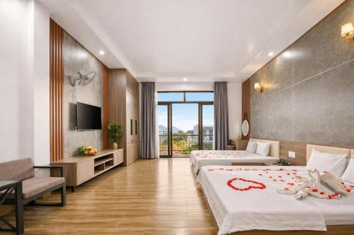 a hotel room with two beds and a television at Valentin Motel 2 Đà Nẵng in Danang