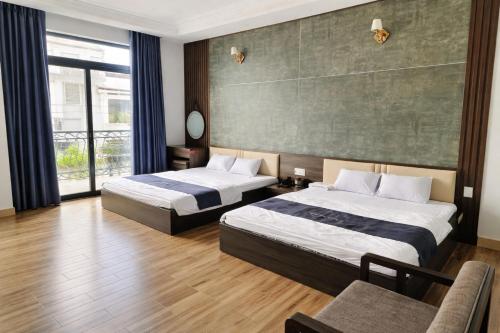 a hotel room with two beds and a couch at Valentin Motel 2 Đà Nẵng in Danang