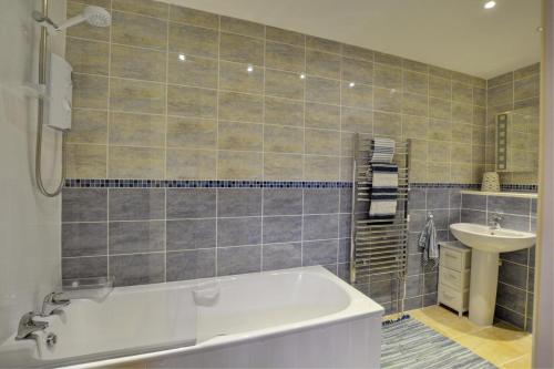 a bathroom with a tub and a sink at 3 Bed in Thursford oc-1793 in Thursford