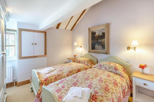a bedroom with two beds and a painting on the wall at 2 Bed in Hellingly oc-b29393 in Warbleton