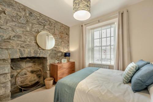 a bedroom with a stone wall with a bed and a mirror at 3 Bed in New Quay oc-c29640 in New Quay