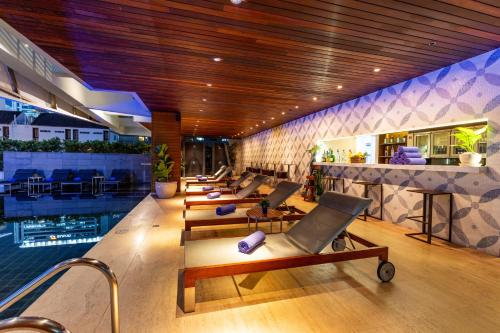 a hotel lobby with a pool and lounge chairs at LiT BANGKOK Hotel in Bangkok