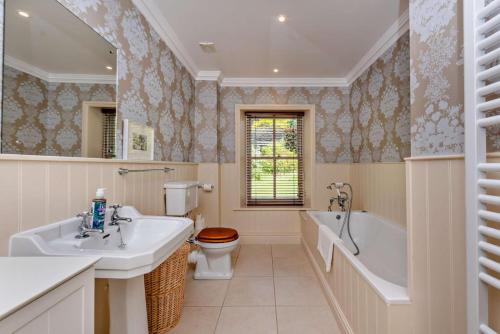 a bathroom with a tub and a toilet and a sink at 6 Bed in Robertsbridge oc-d29525 in Brightling
