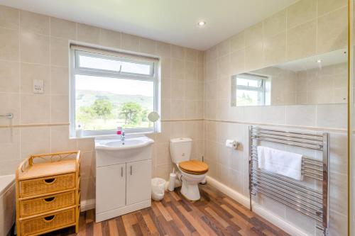 a bathroom with a toilet and a sink and a window at 3 Bed in Hawes oc-s30429 in Hawes