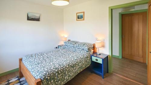 a bedroom with a bed and a table with two lamps at 1 Bed in Reef oc-r30134 in Uig