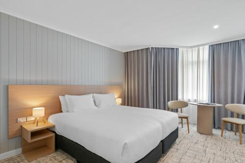 a hotel room with a large bed and chairs at Silkari Mirage at Newport in Newport
