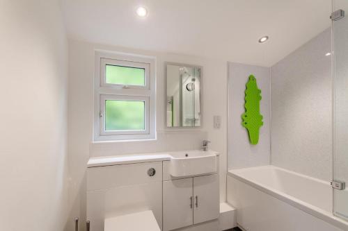 a white bathroom with a sink and a bath tub at 3 Bed in Beer oc-b31132 in Beer