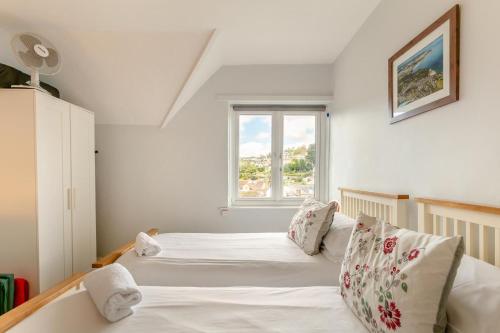 a bedroom with two white beds and a window at 3 Bed in Beer oc-b31132 in Beer