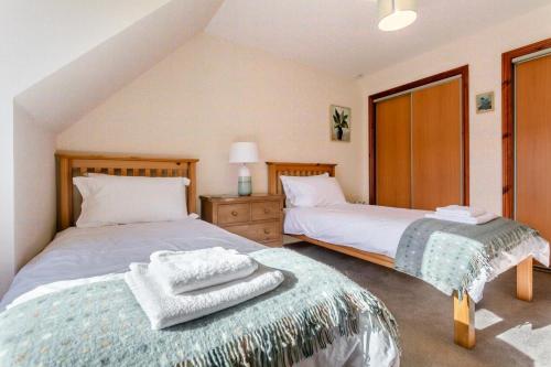 a bedroom with two beds with towels on top of it at 3 Bed in Strathkanaird oc-r30948 in Ullapool