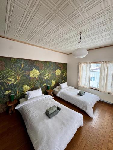 a room with three beds and a wall with plants at Blanco Escape in Myoko