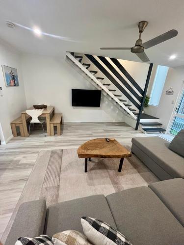 a living room with a couch and a table at The Lazy Break at Trinity in Trinity Beach