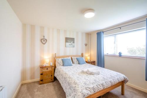 a bedroom with a bed with blue pillows and a window at 2 Bed in Abersoch oc-c31969 in Abersoch