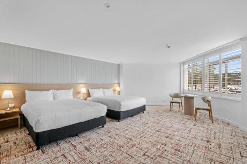 a hotel room with two beds and a window at Silkari Mirage at Newport in Newport