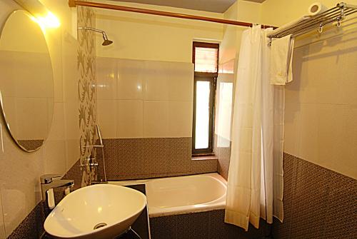 y baño con lavabo, bañera y ducha. en Hotel Amaryllis, en Katmandú