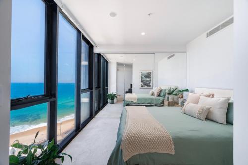 a bedroom with a bed with a view of the ocean at 1010 - Elite Escape - Absolute Beachfront Luxury in Newcastle