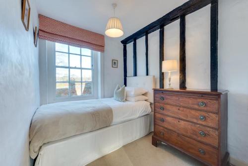 a bedroom with a bed and a dresser and a window at 4 Bed in Barham oc-ct016 in Barham