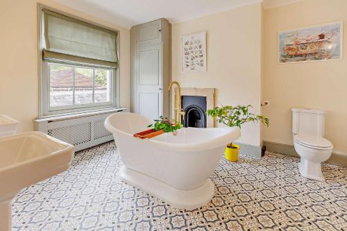 a bathroom with a tub and a toilet and a fireplace at 5 Bed in Sedlescombe oc-l27505 in Sedlescombe