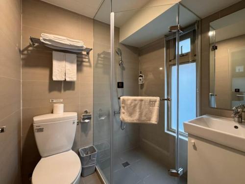 a bathroom with a toilet and a sink and a shower at Lumos Inn 拾光行旅 in Taipei