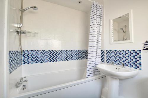 a bathroom with a tub and a sink and a toilet at 2 Bed in Hunstanton oc-1778 in Hunstanton