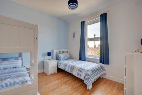 a bedroom with a bed and a window with blue curtains at 2 Bed in Hunstanton oc-1778 in Hunstanton