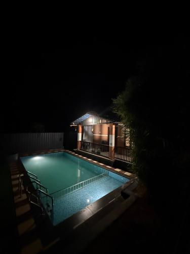 a swimming pool at night with a house at Wayanad Cocos Villa in Tariyod