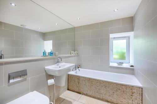a white bathroom with a sink and a bath tub at 3 Bed in Bamburgh oc-gd0468 in Bamburgh