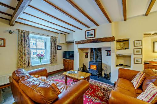 a living room with leather furniture and a fireplace at 3 Bed in Hawes oc-hhmy23 in Hawes