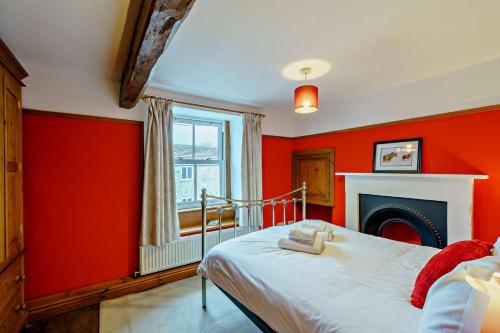 a red bedroom with a bed and a fireplace at 3 Bed in Hawes oc-hhmy23 in Hawes