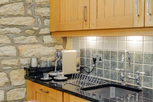 a kitchen with a sink and a stone wall at 3 Bed in Warkworth oc-nb400 in Warkworth