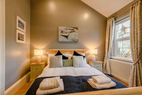 a bedroom with a bed with two lamps and a window at 3 Bed in Warkworth oc-nb400 in Warkworth