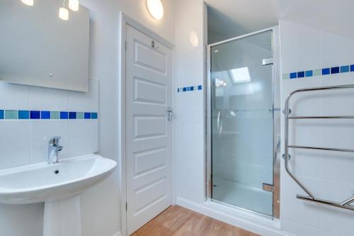 a white bathroom with a shower and a sink at 3 Bed in Fowey oc-p00755 in Fowey