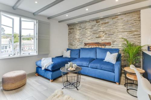 a blue couch in a living room with a stone wall at 2 Bed in Padstow oc-p00876 in Padstow