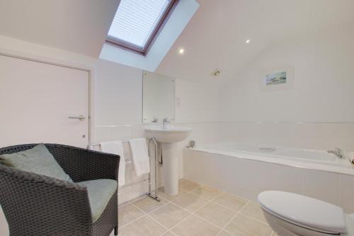 a bathroom with a toilet a sink and a bath tub at 2 Bed in Porthleven oc-quaysi in Porthleven