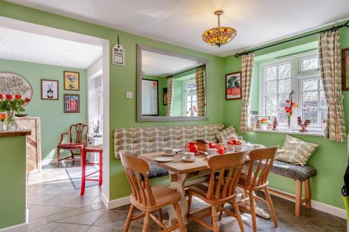 a dining room with green walls and a table and chairs at 3 Bed in Portesham oc-wy550 in Portesham