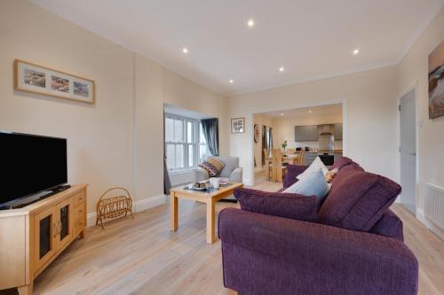 a living room with two purple chairs and a tv at 3 Bed in Saundersfoot oc-pw9274 in Saundersfoot