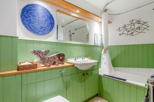 a green bathroom with a sink and a mirror at 3 Bed in Portesham oc-wy550 in Portesham