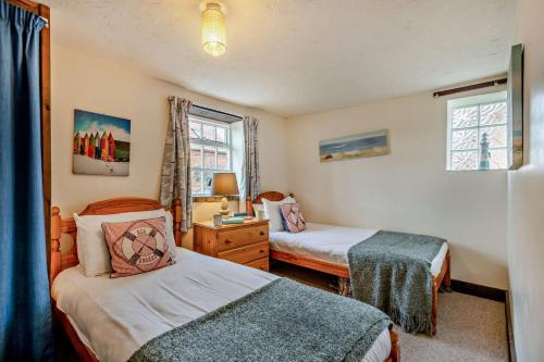 a bedroom with two beds and a desk and a window at 3 Bed in Brancaster oc-p28395 in Brancaster