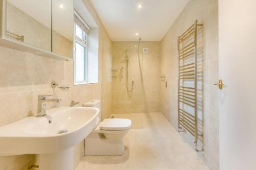a white bathroom with a sink and a toilet at 2 Bed in South Molton oc-willo in South Molton
