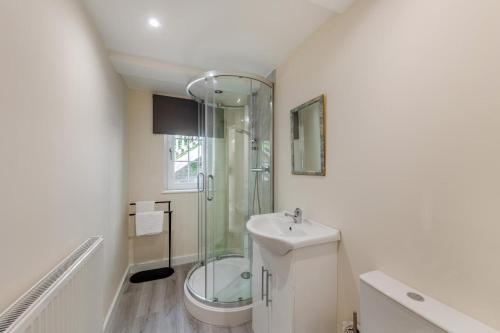 a bathroom with a glass shower and a sink at 3 Bed in Aberdovey oc-v29263 in Aberdyfi