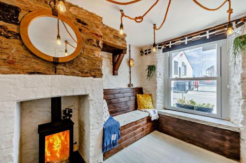 a living room with a fireplace and a window at 2 Bed in Looe oc-a29612 in Looe