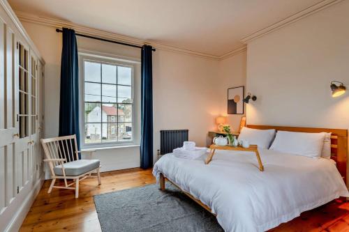 a bedroom with a bed and a chair and a window at 5 Bed in Methwold oc-r29770 in Methwold