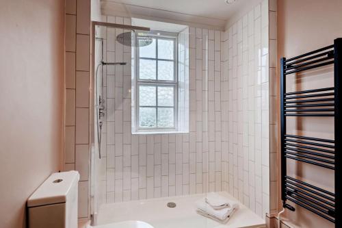 a white bathroom with a shower and a toilet at 5 Bed in Methwold oc-r29770 in Methwold